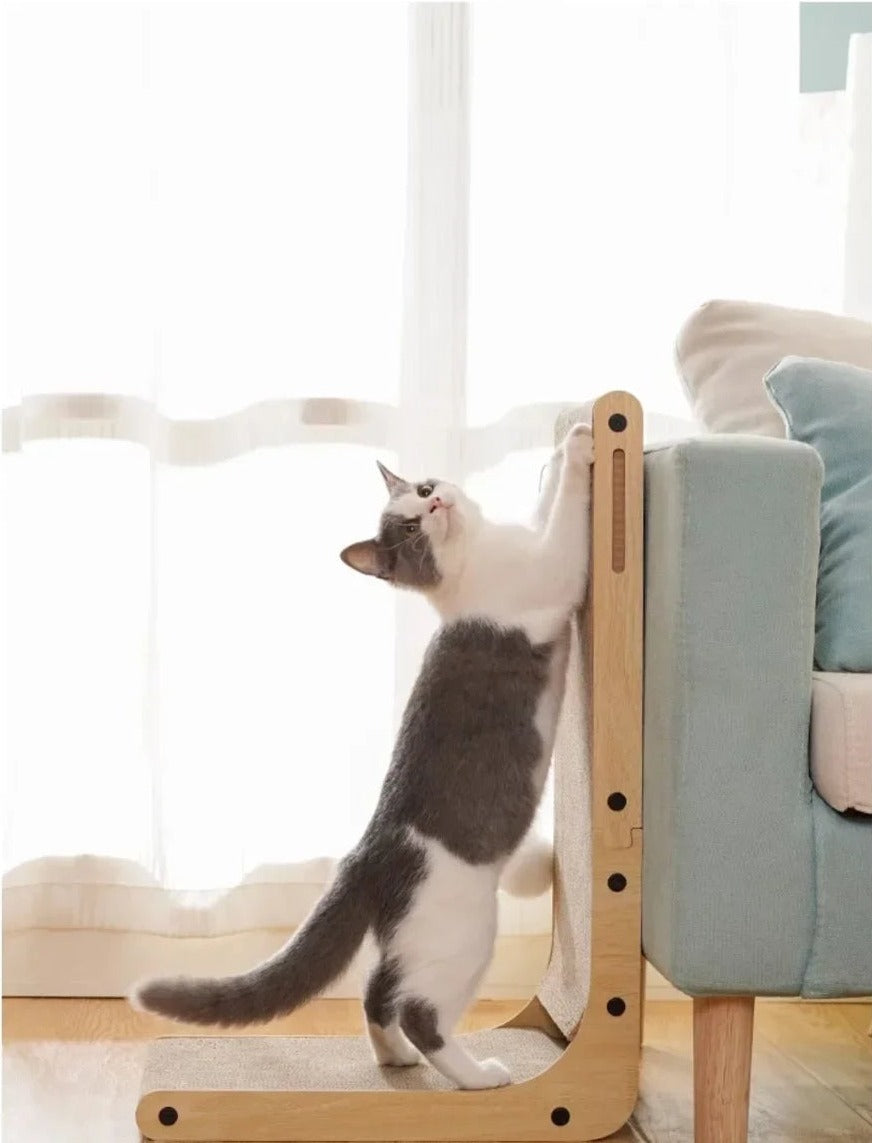 Chat qui fait ses griffes debout sur le griffoir en L posé contre l'accoudoir du canapé (photo du fabricant)