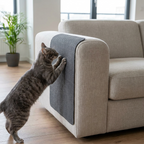 Tapis griffoir gris anthracite posé sur l'accoudoir d'un canapé en lin, un chat gris le griffe (image générée par IA)
